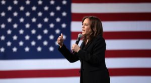 U.S. Senator Kamala Harris speaking with giant American flag behind her.