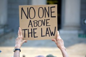 Protester Holding Sign that Reads: No One Above The Law