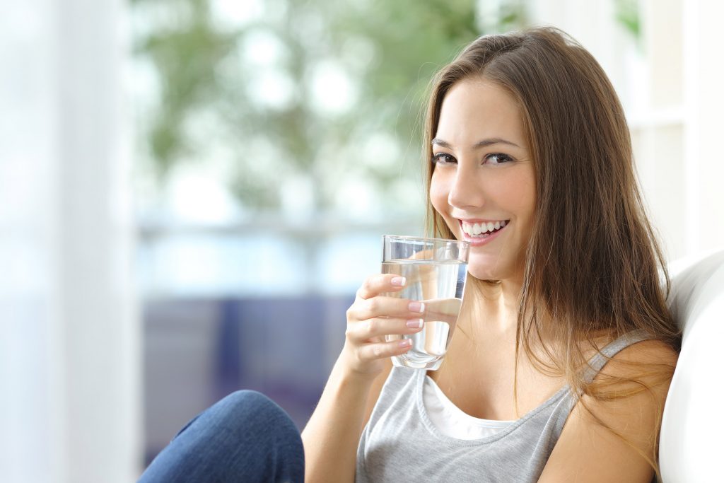 Woman Smiles while Drinking Water filled with PFAs